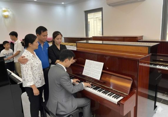 Gia đình cho bé trải nghiệm piano cơ tại showroom trước khi quyết định mua đàn