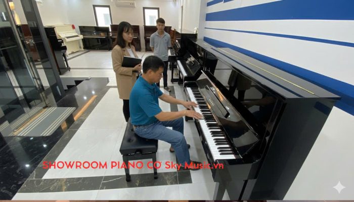 Khách hàng trải nghiệm thử piano cơ trước khi chọn mua cho người mới học