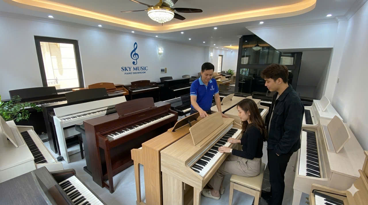 người mới học đang thử đàn piano với sự hướng dẫn trực tiếp tại cửa hàng